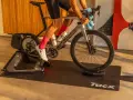 A cyclist trains indoors on a Tacx bike trainer, a device that allows you to ride your bicycle stationary.