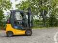 Operator w kasku i kamizelce prowadzi wózek widłowy Jungheinrich. Zastanawiasz się, ile kosztuje uprawnienia na wózek widłowy?