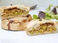 Panades mallorquinas cortadas, mostrando el relleno de guisantes y carne.