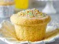 Ein Fanta-Muffin mit Zuckerguss und bunten Streuseln, bereit zum Genießen.