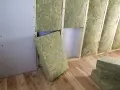 Installazione di materiali coibentanti in lana di roccia per l'isolamento termico di una parete in costruzione.