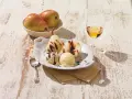 Gegarte Birnen mit Schokoladensauce und cremigem Vanilleeis, garniert mit Lavendelblüten. Ein köstliches Birnen Eis Dessert.