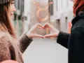 Para z dłońmi tworzącymi serce, nad nimi symbol zodiaku Byk.