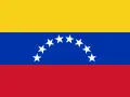 Bandera tricolor con franjas amarilla, azul y roja. En la franja azul, una hilera de estrellas blancas forma un arco. Es una bandera parecida a Francia, pero con estrellas.