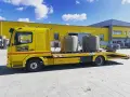 Żółta laweta z dwoma betonowymi elementami, gotowa do transportu. To **assistance warta** uwagi, gdy potrzebujesz przewieźć ciężkie ładunki.