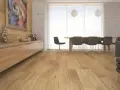 Drewniana podłoga w salonie, panele ułożone wzdłuż pomieszczenia, tworzą ciepłą atmosferę.