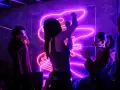 Trzy osoby bawią się przy neonach. Jedna pije, druga tańczy, trzecia klaszcze. W tle neonowe piosenki z układem tanecznym.
