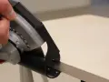 Hand mit Ring hält Winkelschleifer zum präzisen Fliesenschneiden.