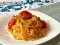 Spaghetti alla bottarga con pomodorini e prezzemolo, un piatto saporito e profumato.