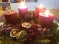 Adventskranz mit vier roten Kerzen, Tannenzweigen, Beeren, getrockneten Früchten und kleinen Äpfeln. Der 6. Sonntag nach Ostern ist noch weit, aber die Vorfreude auf Weihnachten ist spürbar.