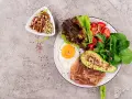Śniadanie LCHF: jajko sadzone, boczek, awokado, sałatka z truskawkami i orzechy. Idealne na początek dnia, gdy zastanawiasz się lchf co to.