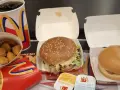 Zestaw McDonald's: burger, frytki, nuggetsy, napój i sosy.