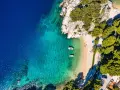 Chorwacja gdzie na wakacje? Rajska plaża z krystalicznie czystą wodą, łódkami i zielonymi wzgórzami. Idealne miejsce na relaks.