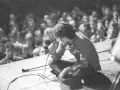 Jim Morrison z The Doors na scenie, wpatrzony w tłum. Jego "Paris Blues" rozbrzmiewa w sercach fanów.