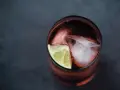 Czerwony drink z lodem i limonką. Idealny do degustacji z brandy Kazbek Peak, odkryj nowe smaki!