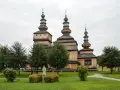 Drewniana cerkiew z trzema kopułami, otoczona zielenią. Wspaniałe krempna atrakcje dla miłośników historii i architektury.