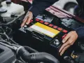 Mechaniker tauscht Batterie aus, da die Lichtmaschine defekt oder die Batterie leer ist.
