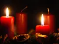 Two red candles glow, marking the 2nd advent. A festive wreath with dried orange slices and pine needles surrounds them.