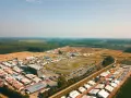 Vista aerea di un circuito **ottobiano motorsport** con paddock, tribune e pista da cross sullo sfondo, immerso nel verde.