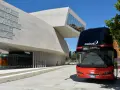 Autobus Itabus rosso e nero davanti a un edificio moderno con la scritta "More Than Meets The Eye". Un viaggio da Verona a Jesolo?