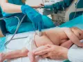 Lekarz wykonuje USG bioderka u niemowlaka. Badanie jest ważne dla prawidłowego rozwoju malucha.