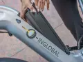 Mani che inseriscono la batteria in una bici elettrica. La durata della batteria di una bici elettrica è fondamentale per l'autonomia.
