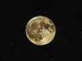 Luna llena, como si se pudiera cargar piedras lunares bajo su luz. El cielo estrellado la rodea.