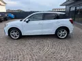 Audi Q2 bianca parcheggiata su pavé. Controlla la pressione pneumatici per un viaggio sicuro.