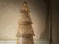 Un sapin de Noël en tissu à faire soi-même, fait de cônes tressés et illuminé de guirlandes lumineuses.