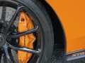 Pomarańczowy zacisk hamulcowy McLaren na czarnym, wieloramiennym kole. Opona z napisem 225/35 ZR19.