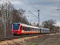 Czerwono-biały pociąg SKM S2 Chopin Airport jedzie po torach. System monitoringu ruchu pociągów śledzi jego trasę.