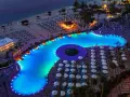Luksusowy basen z niebieskim podświetleniem i leżakami na plaży w Dubaju.