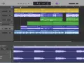 Interfejs programu GarageBand z wieloma ścieżkami audio: wokal, gitara, bas i klawisze. Widoczne fale dźwiękowe i nazwy instrumentów.