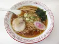 Miseczka aromatycznego ramenu, dania, którego **ramen skąd pochodzi** jest z Japonii. Widać makaron, plastry mięsa, nori, bambus i narutomaki.