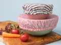 Trois couvre-plats en tissu avec des motifs différents, empilés sur des bols. Un tuto pour les réaliser soi-même.