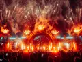 Spektakularny pokaz fajerwerków i płomieni na scenie podczas festiwalu Sunrise Festival 2026. Tłum ludzi z telefonami wzniesionymi ku górze.