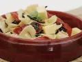 Deliciosa pasta farfalle con tomates secos, aceitunas negras, albahaca y cubos de queso. Una de las mejores recetas de pasta para disfrutar.