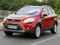 Czerwony Ford Kuga, idealny SUV do 40 tys. zł, jedzie po drodze.