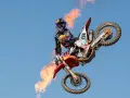 Motociclista Jorge Prado en el aire con llamas saliendo de su moto.
