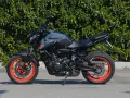 Yamaha MT-07 grigia con cerchi arancioni, pronta a scatenare la sua velocità massima.