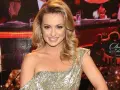 Uśmiechnięta Aleksandra Grabowska w złotej sukni z cekinami, na tle sceny "Dancing with the Stars".
