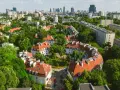 Zielony Żoliborz Oficerski z charakterystyczną architekturą i panoramą miasta w tle.