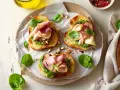 Aromatyczne kanapki z pesto, szynką i świeżą bazylią, posypane migdałami. Idealne na szybką przekąskę.