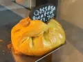 Złociste, pieczone ciasto z nadzieniem, typowe maltańskie jedzenie. Na tabliczce napis "Cassata Ricotta €1.70".