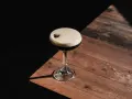 Espresso Martini przepis: elegancki koktajl z pianką i ziarnem kawy na drewnianym blacie.