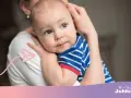 Ciepły uścisk mamy, kiedy dziecko zaczyna się przytulać. Maluch w pasiastym ubranku wtula się w nią z ufnością.