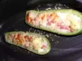 Zucchine ripiene di riso, condite con pomodoro e formaggio, pronte per essere gustate.