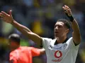 Jude Bellingham, con los brazos en alto, celebra un gol. El joven jugador del Dortmund, con su camiseta blanca, inspira a la afición.