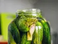 En burk med inlagda gurkor, dill och vitlök. Perfekt för ett gott saltgurka recept.