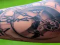 Un tatouage réaliste d'une montre à gousset avec des engrenages complexes. Une œuvre d'art qui témoigne d'une formation dessin tatouage.